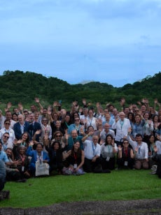 A group of congressgoers gather for a photo all waving to the camera