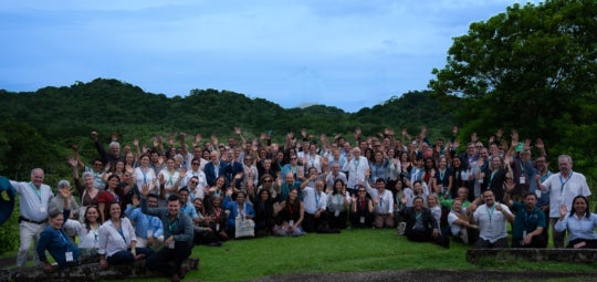 A group of congressgoers gather for a photo all waving to the camera